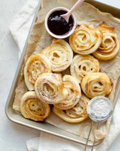 Puff Pastry Rolls being sprinkled with powdered sugar
