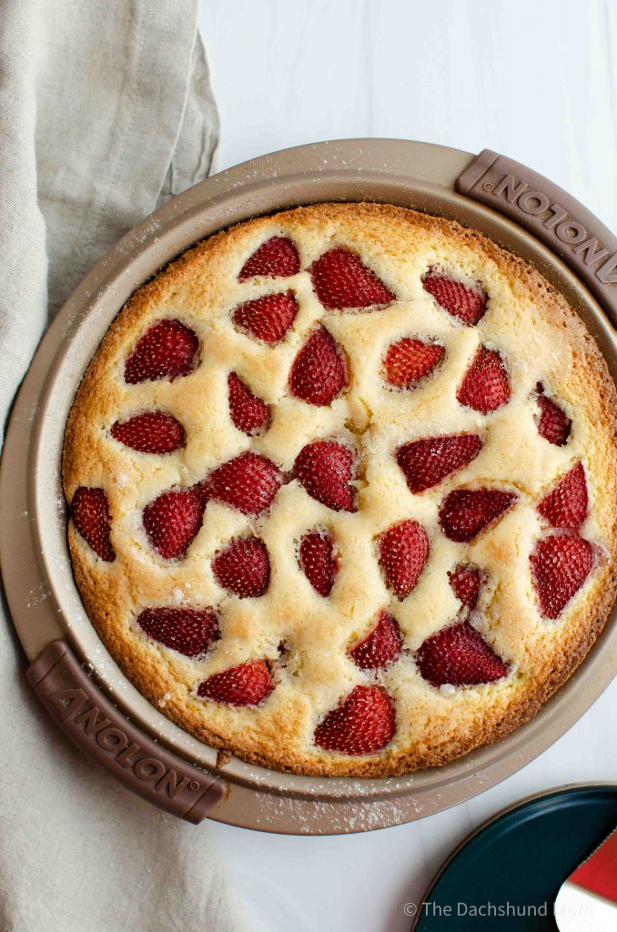 Baked strawberry cornmeal cake cooling in a baking pan.